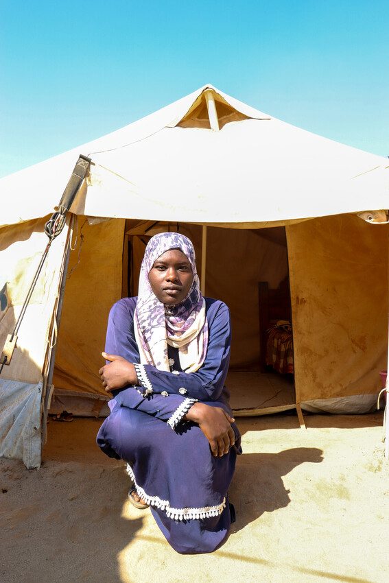 Mehad, 18, in front of the tent she shares with her family.